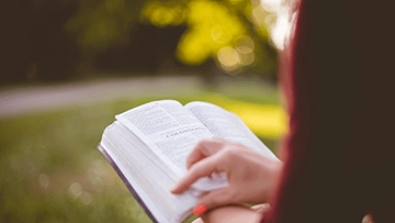 Mujer leyendo libro en biblioteca